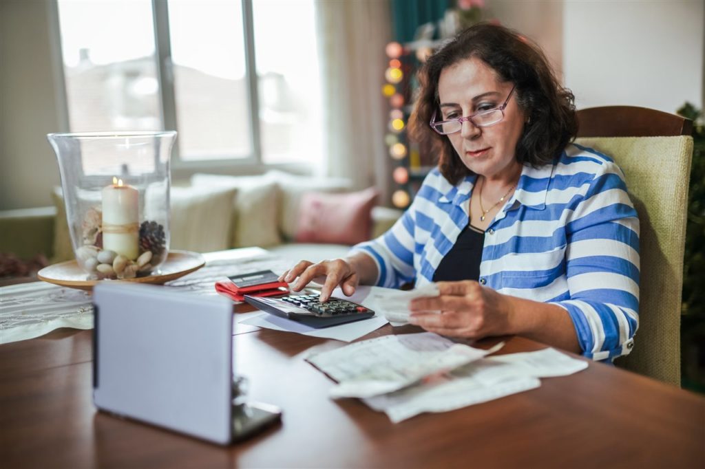 Woman with calculator and laptop computer